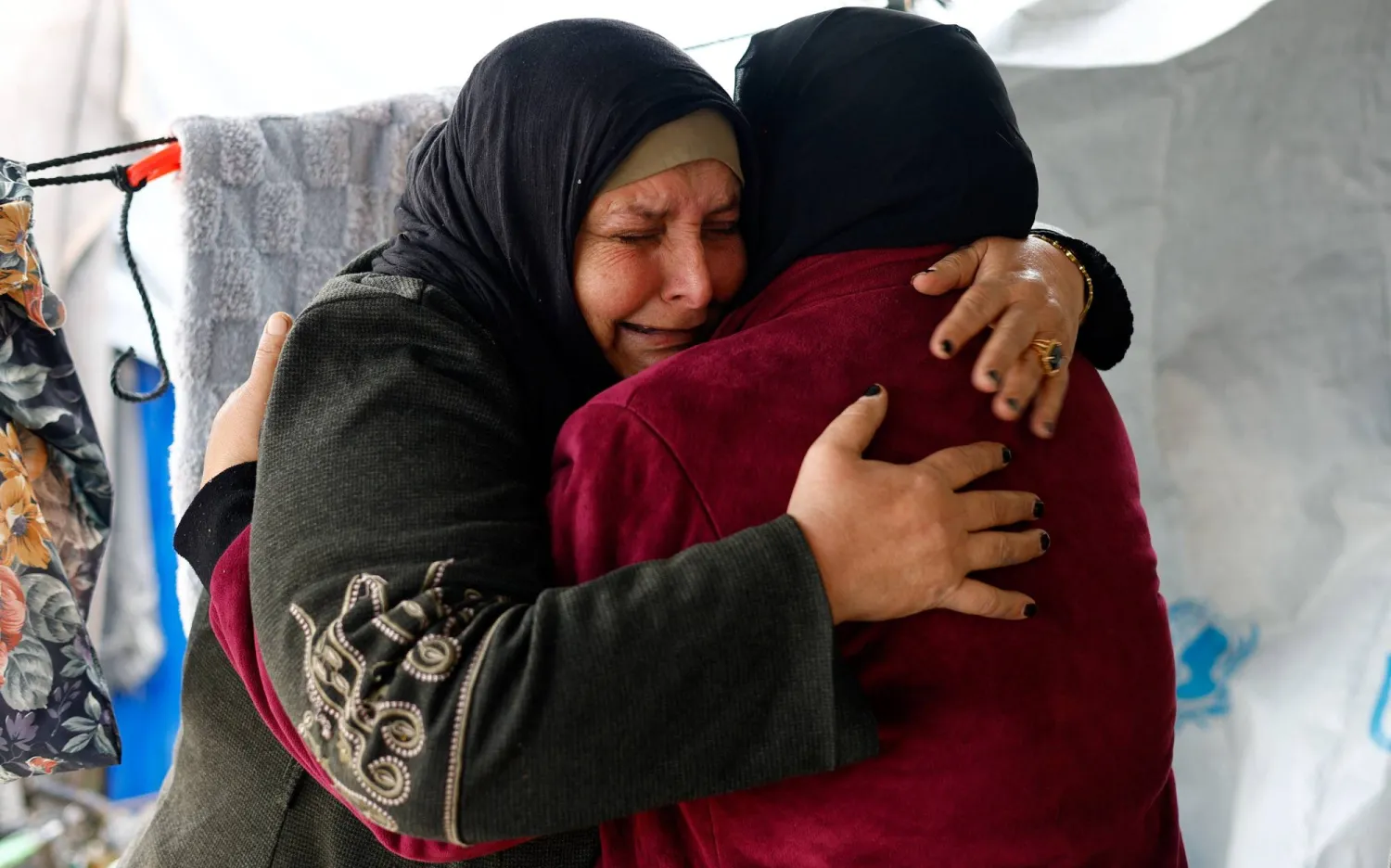  Huda Abu Abed, 56, cries as she is embraced by her sister inside a tent after returning to Gaza through the Rafah crossing, in Khan Younis in the southern Gaza Strip, February 3, 2026. (Reuters)