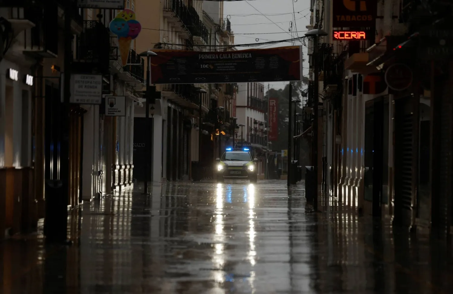 A police car patrols an empty shopping area amid rain as storm Leonardo hits parts of Spain, in Ronda, Spain, February 4, 2026. (Reuters)