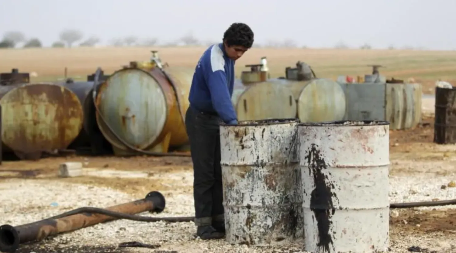 Caption: A youth works at a makeshift oil refinery site in Marchmarin town, southern countryside of Idlib, Syria December 16, 2015. REUTERS/Khalil Ashawi
