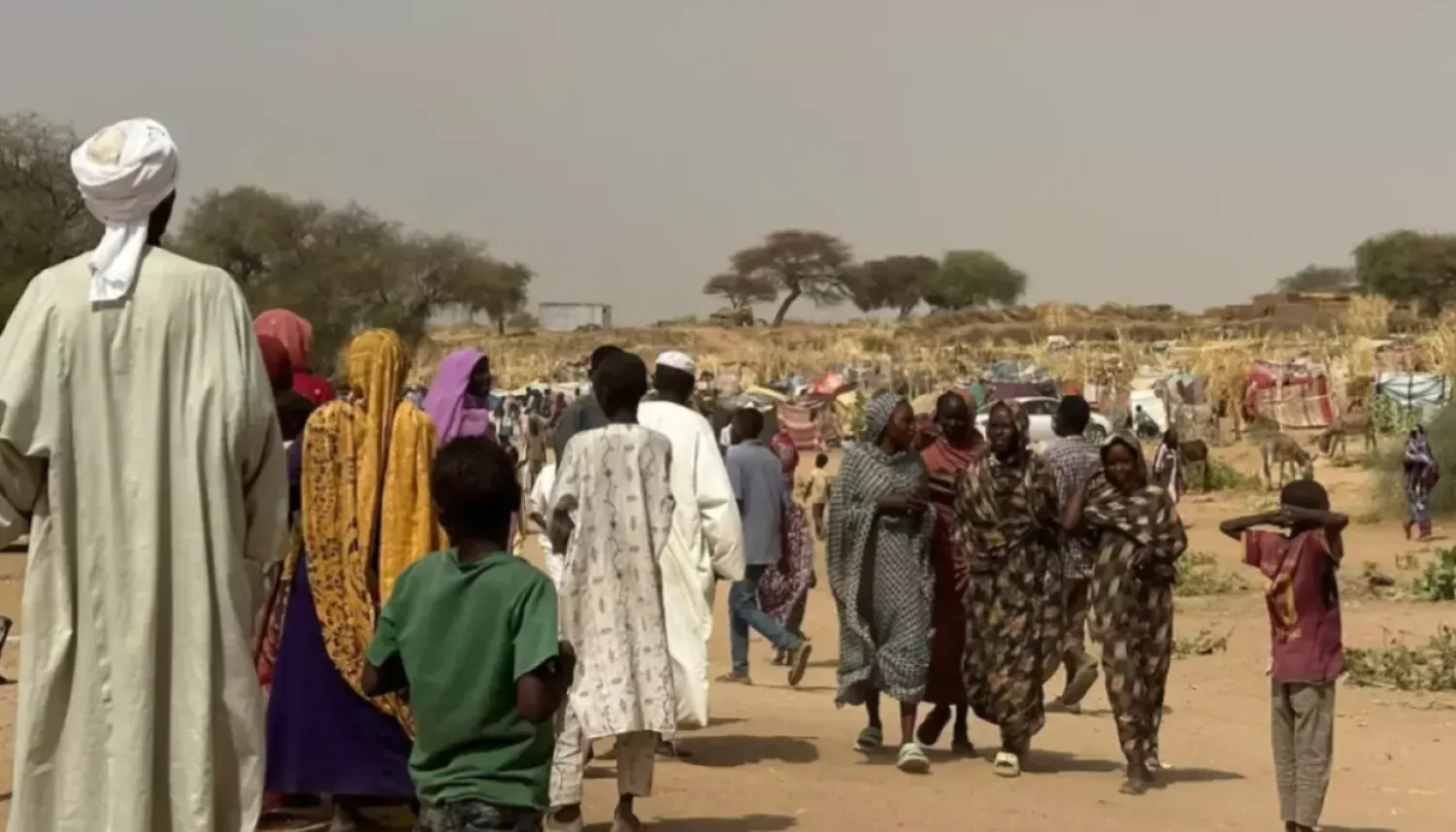 People who fled the Zamzam camp for the internally displaced walk in a makeshift encampment in an open field near the town of Tawila in war-torn Sudan's western Darfur region on April 13, 2025. © AFP
