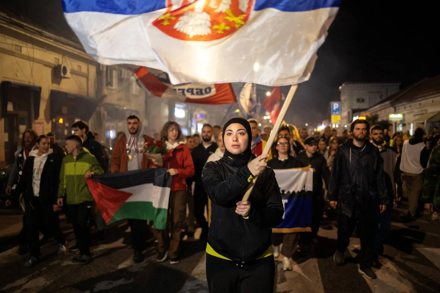 ميريما أفديتش تحمل العلم الصربي خلال المسيرة (رويترز)