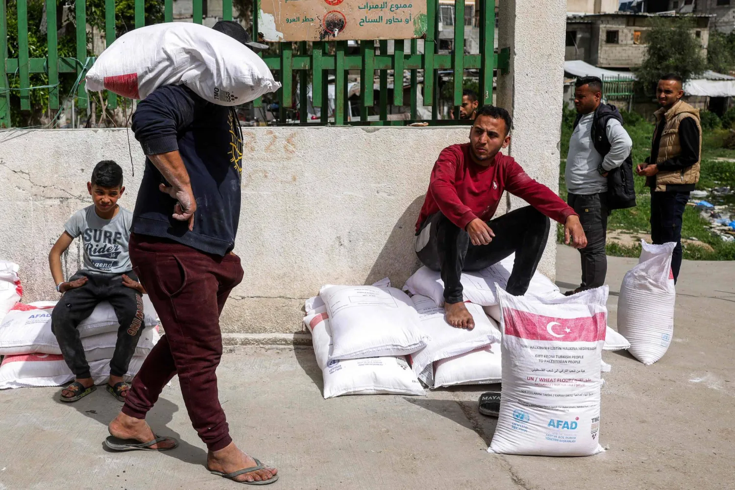 نازحون فلسطينيون تسلموا أكياس طحين من مركز تابع لـ«الأونروا» بمدينة غزة - 1 أبريل 2025 (أ.ف.ب)