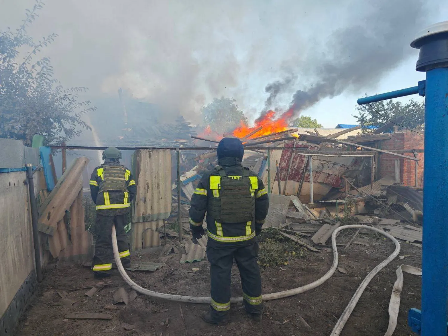 أرشيفية لرجال إطفاء يعملون خارج مبان اشتعلت فيها النيران جراء القصف في بيلغورود (رويترز)