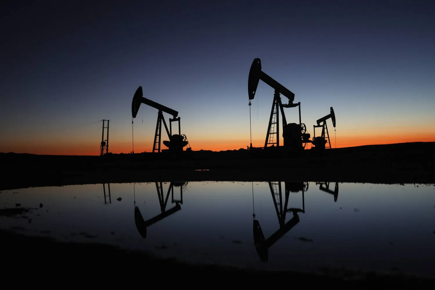 The sun rises behind the Tishrin oil field in the eastern Hasakah countryside, northeastern Syria (AP)