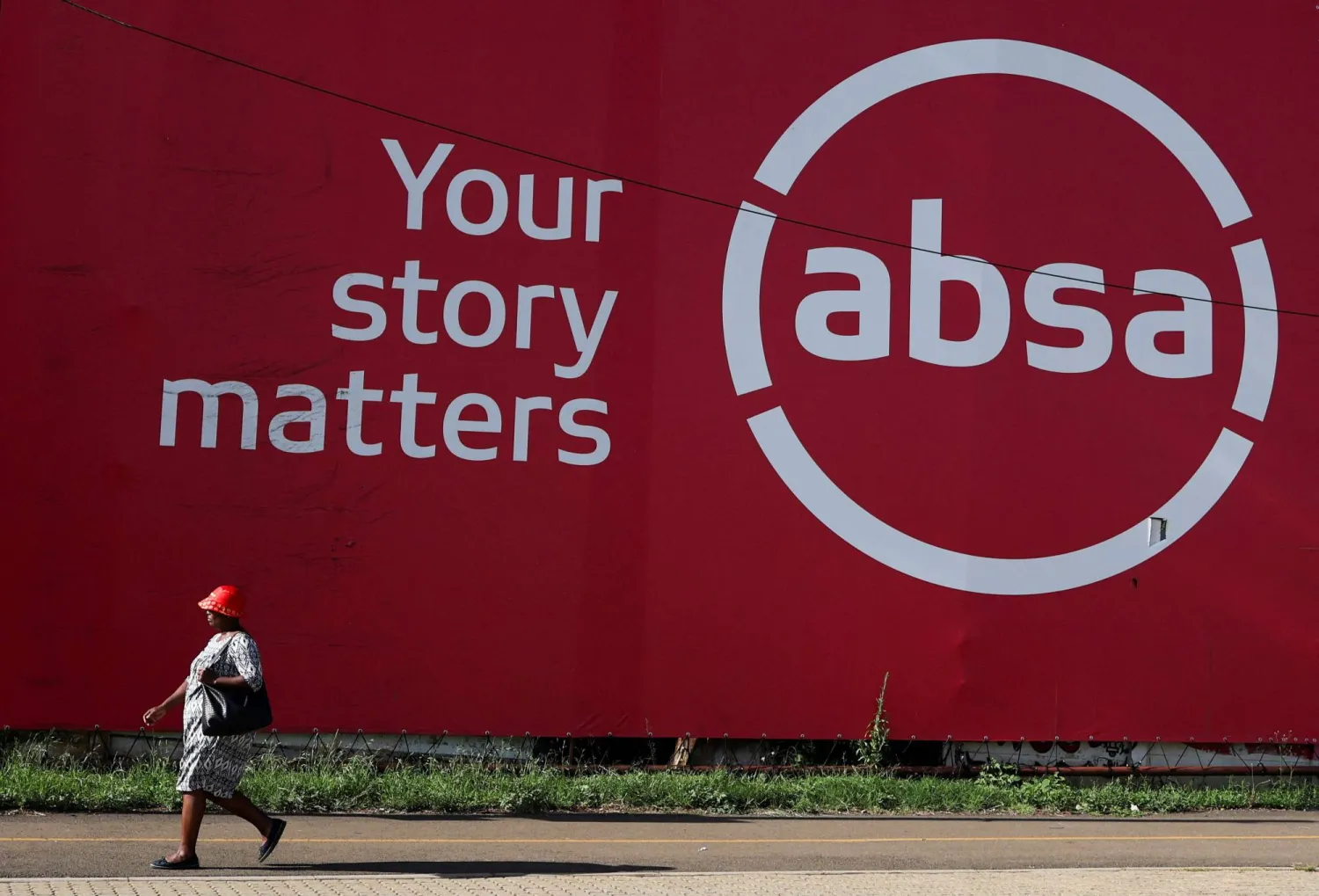 رجل يمر أمام مقر أحد البنوك المحلية في مدينة سويتو بجنوب أفريقيا (رويترز)