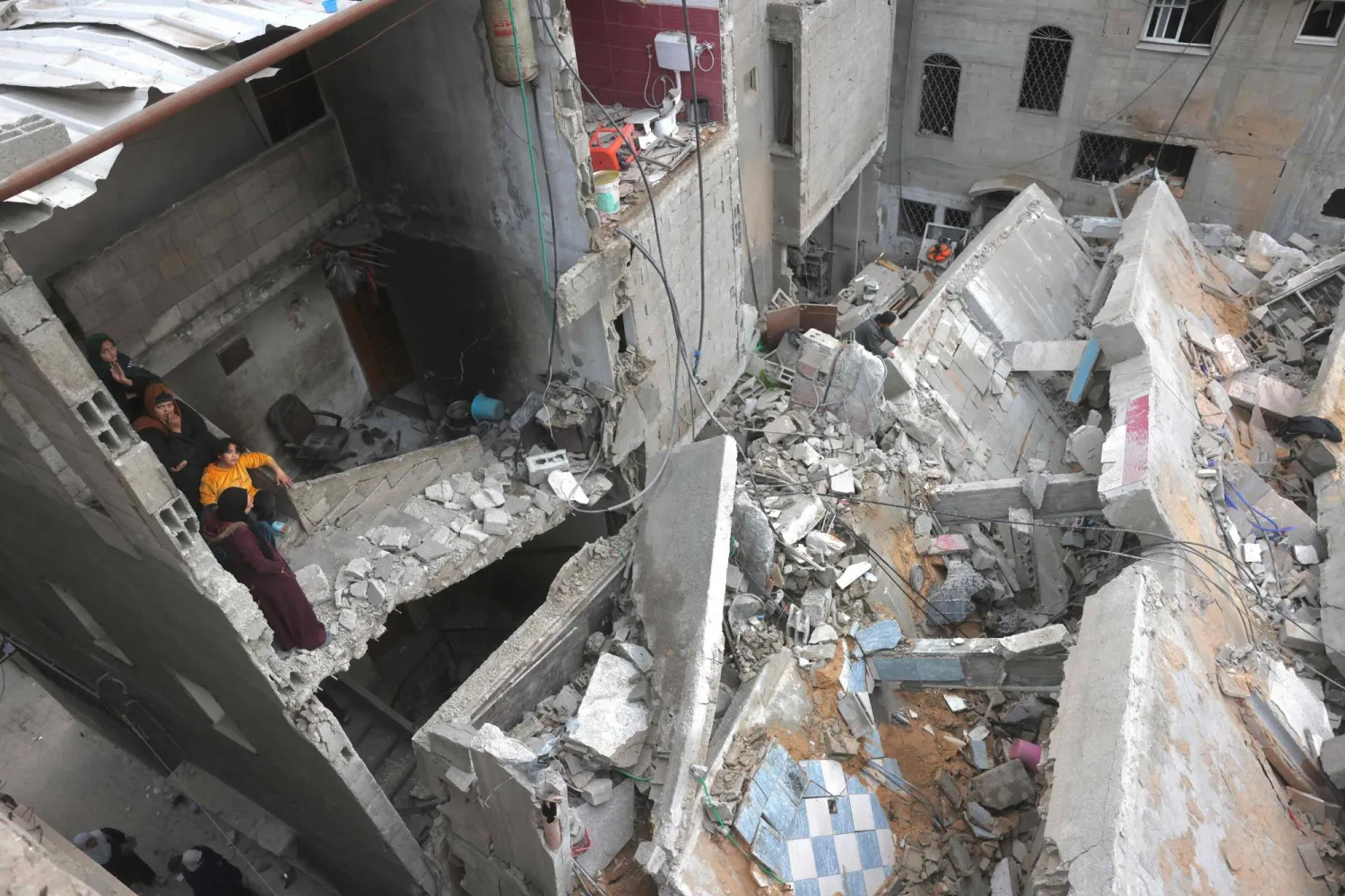 Displaced Palestinians inspect the damage after Israeli aircraft targeted a five floor house last night, in Khan Younis southern Gaza Strip on February 6, 2026. (AFP)