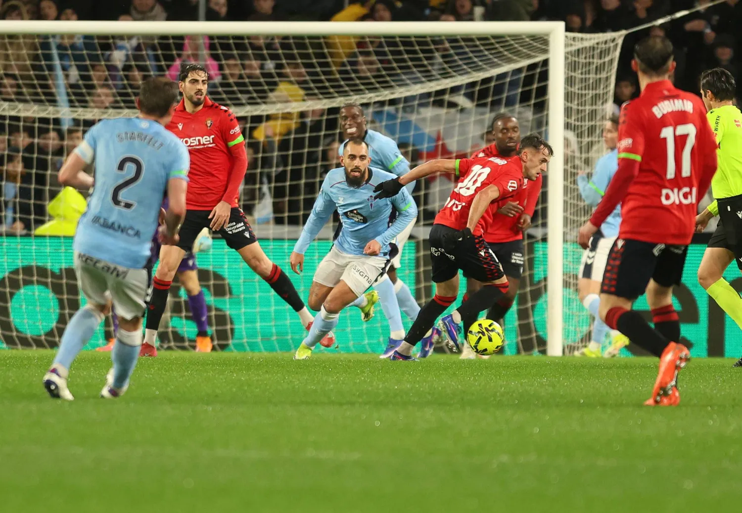 لاعب وسط أوساسونا إيمار أوروز يلعب الكرة تحت ضغط من مهاجم سيلتا فيغو بورخا إيغليسياس (إ.ب.أ).