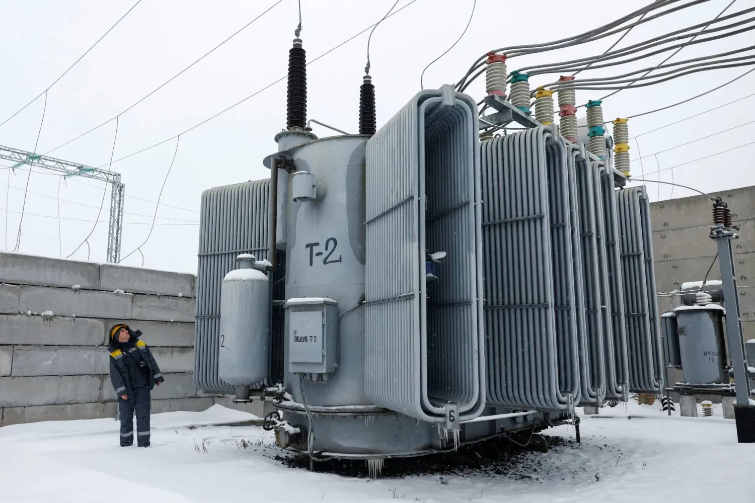 Rus İHA’ları ve füze saldırıları Kiev'deki hayati öneme sahip sivil altyapıya ciddi hasar verdikten sonra, bir enerji şirketinin çalışanı bir elektrik trafosunu inceliyor, (Reuters)