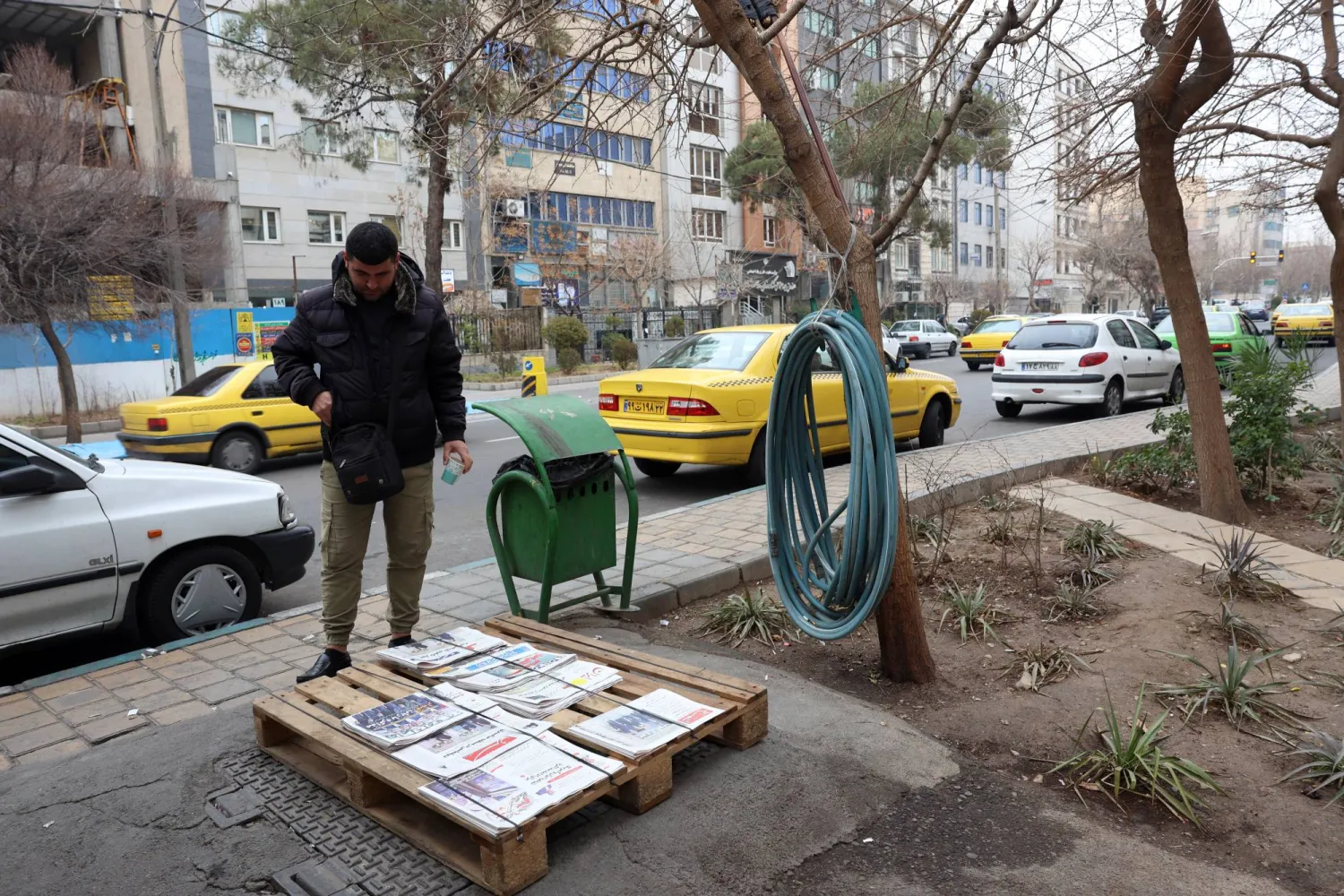 رجل إيراني يطالع العناوين على كشك لبيع الصحف في طهران اليوم (إ.ب.أ)