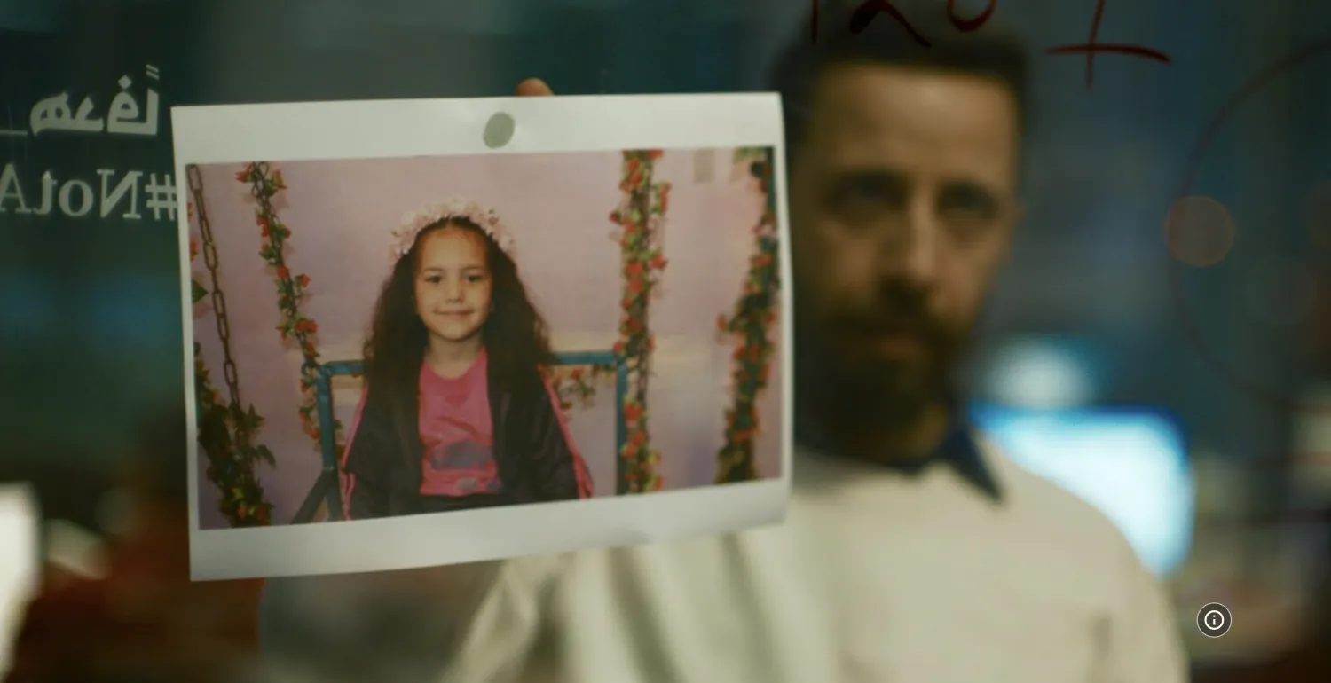 الممثل معتز ملحيس وأمامه صورة الطفلة هند رجب في مشهد من الفيلم