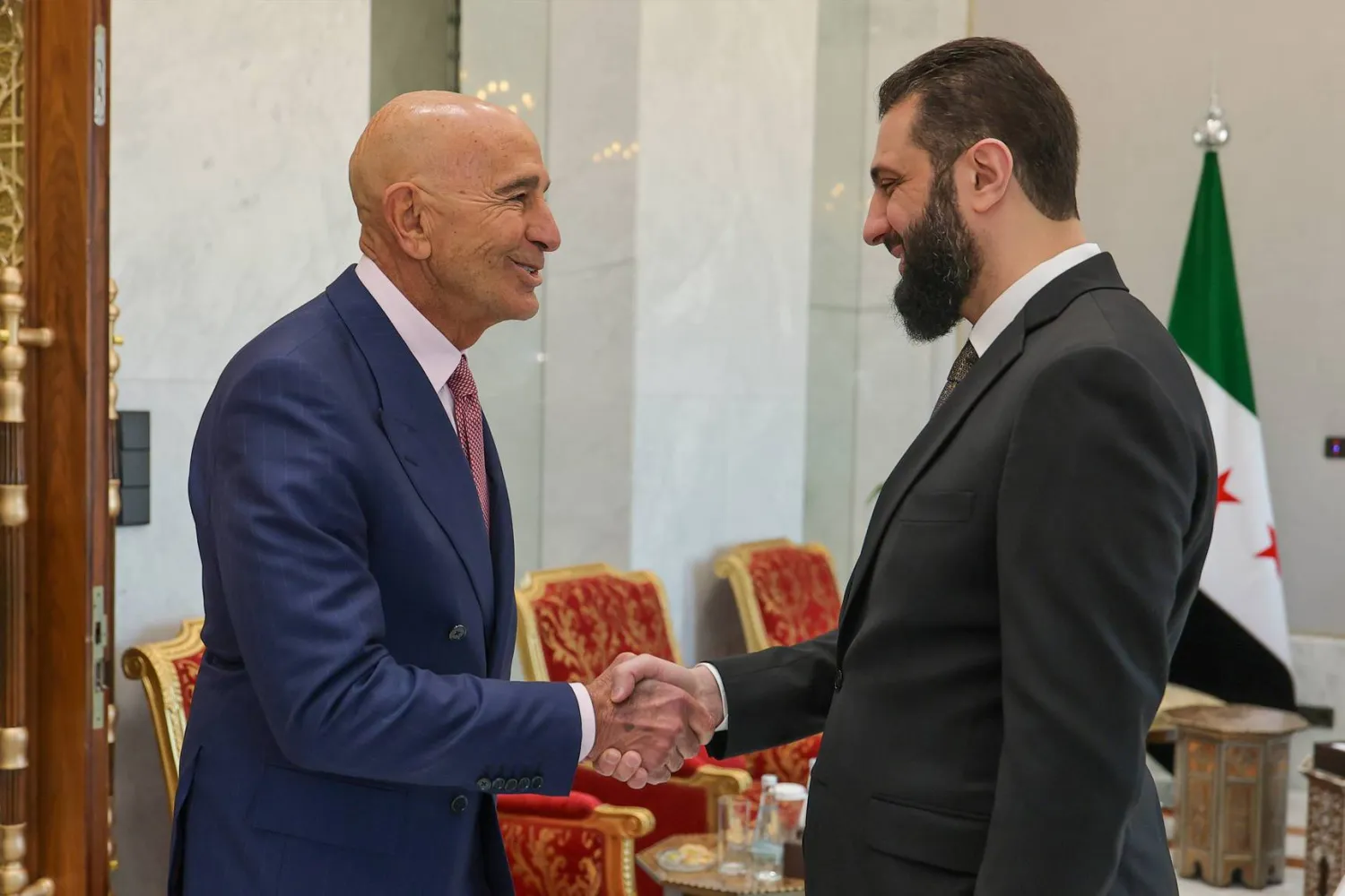 الرئيس السوري أحمد الشرع يصافح المبعوث الأميركي توماس برّاك (د.ب.أ)