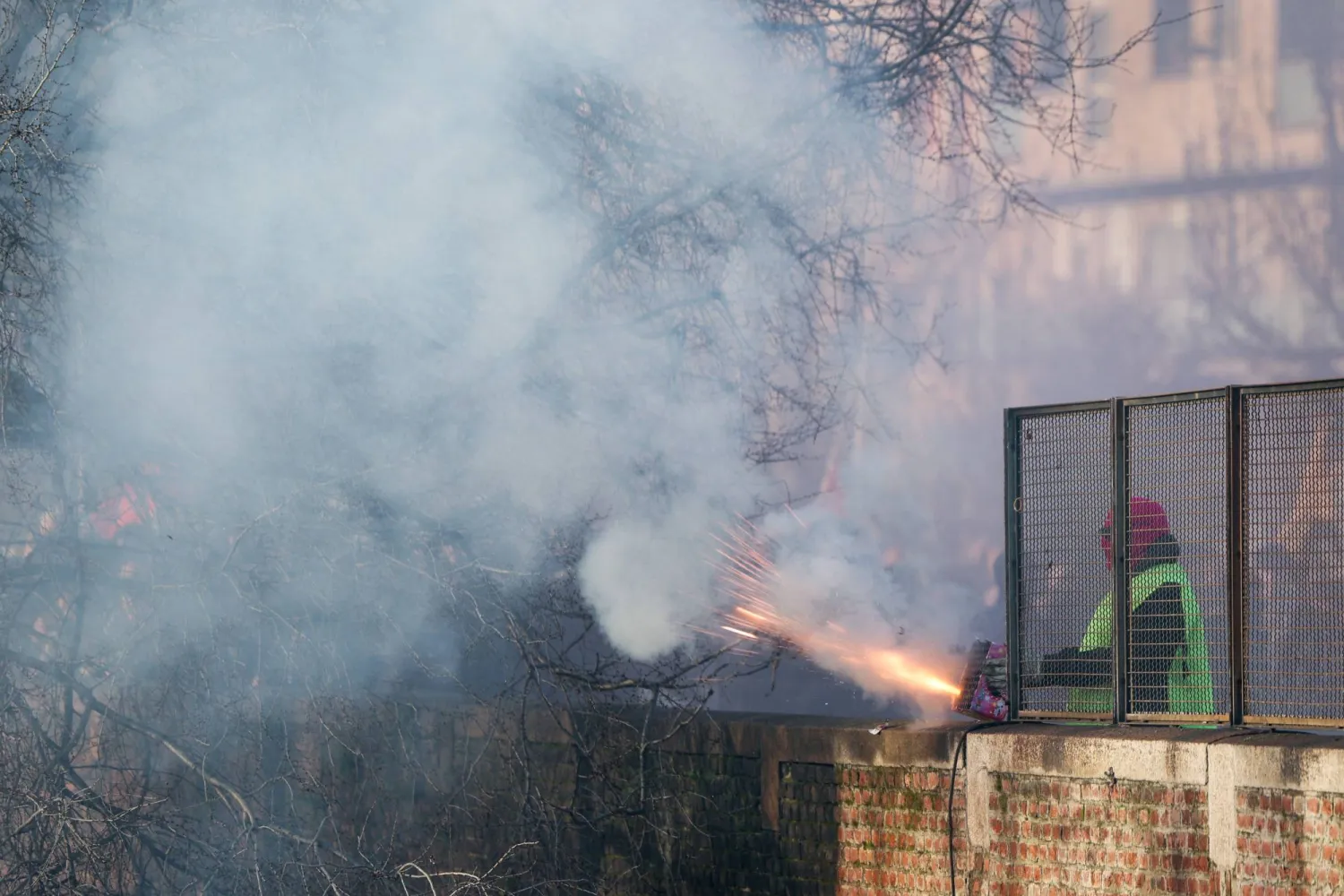  A protester sets off fireworks during a protest against the environmental, economic and social impact of the Milano-Cortina 2026 Winter Olympics, near the Olympic Village in Milan, Italy, February 7, 2026. (Reuters)