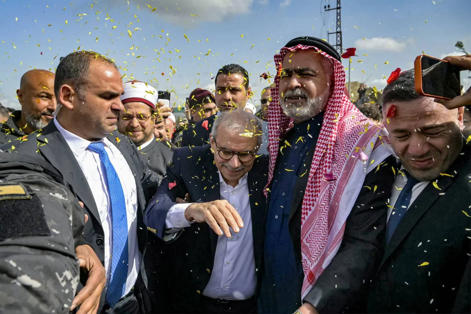 This handout picture released by the Lebanese Government Press Office shows Lebanon's Prime Minister Nawaf Salam being showered with confetti as he is received by locals during a tour in the heavily-damaged southern village of Dhayra near the border with Israel on February 7, 2026. (Lebanese Government Press Office / AFP) 