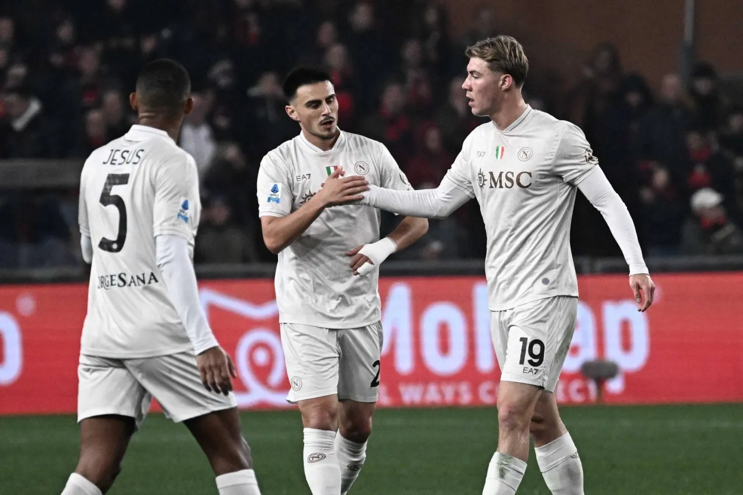 راسموس هويلوند لاعب نابولي يحتفل مع زملائه بعد تسجيله هدفاً خلال مباراة فريقه أمام جنوى (إ.ب.أ)