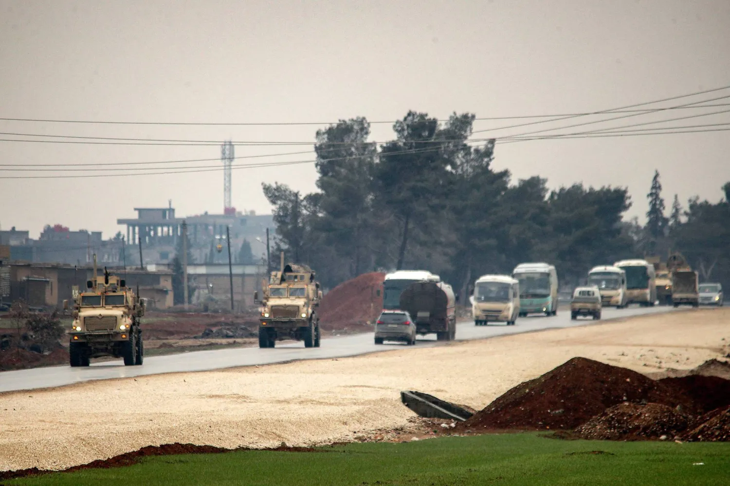 US military vehicles move along a road in a convoy transporting ISIS detainees being transferred to Iraq from Syria, on the outskirts of Qahtaniyah in Syria's northeastern Hasakah province on February 7, 2026. (Photo by Delil SOULEIMAN / AFP)