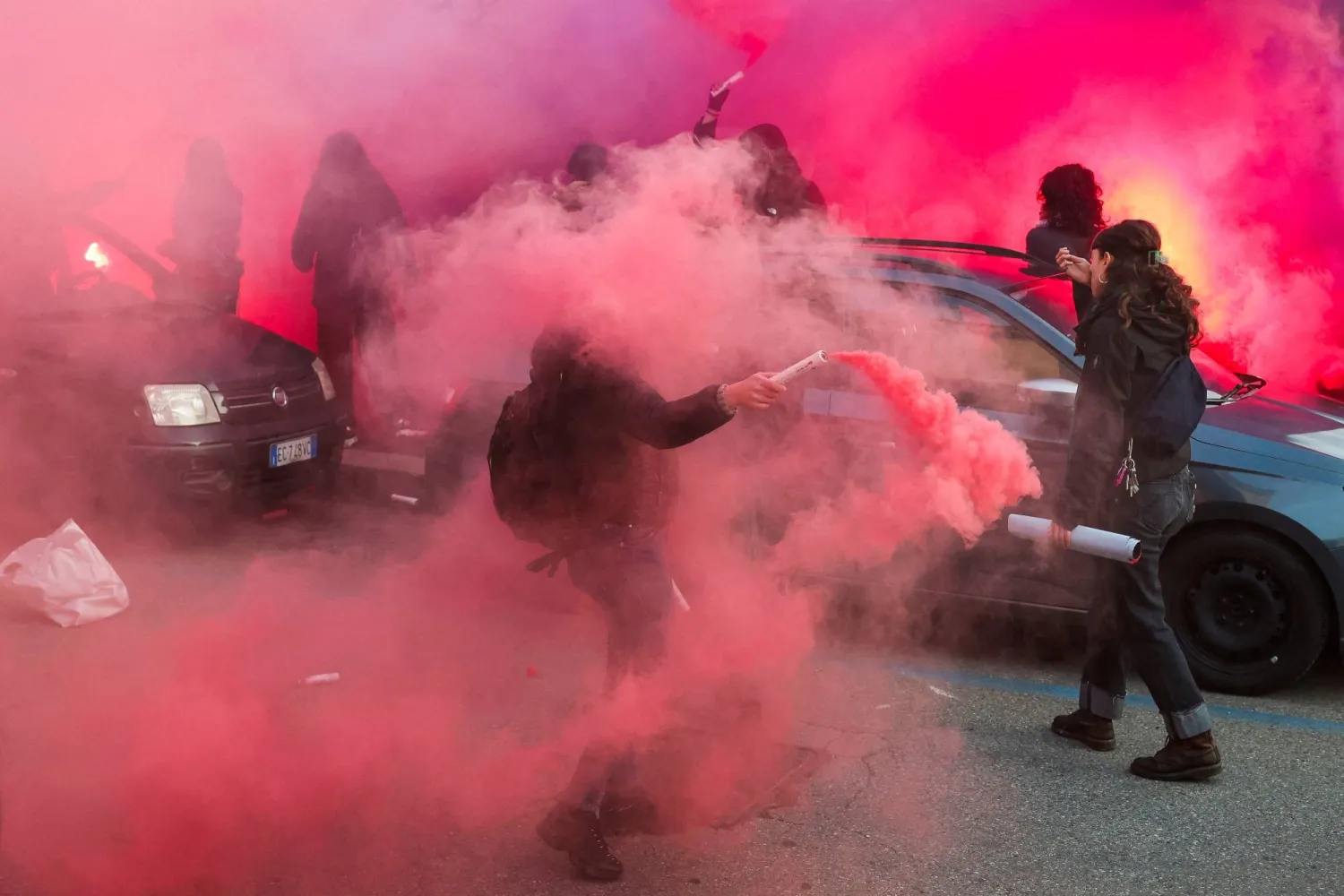 Demonstrators hold smoke flares during a protest against the environmental, economic and social impact of the Milano-Cortina 2026 Winter Olympics in Milan, Italy, February 7, 2026. REUTERS/Kevin Coombs