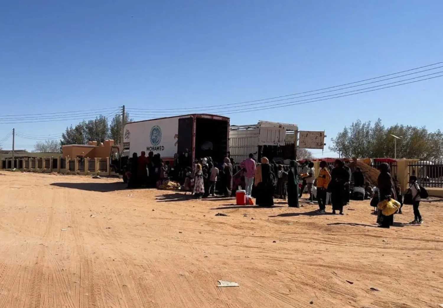Sudanese families prepare to ride on trucks while on their way to Egypt through the Qustul border, after the crisis in Sudan's capital Khartoum, in the Sudanese city of Wadi Halfa, Sudan May 1, 2023. (Reuters)
