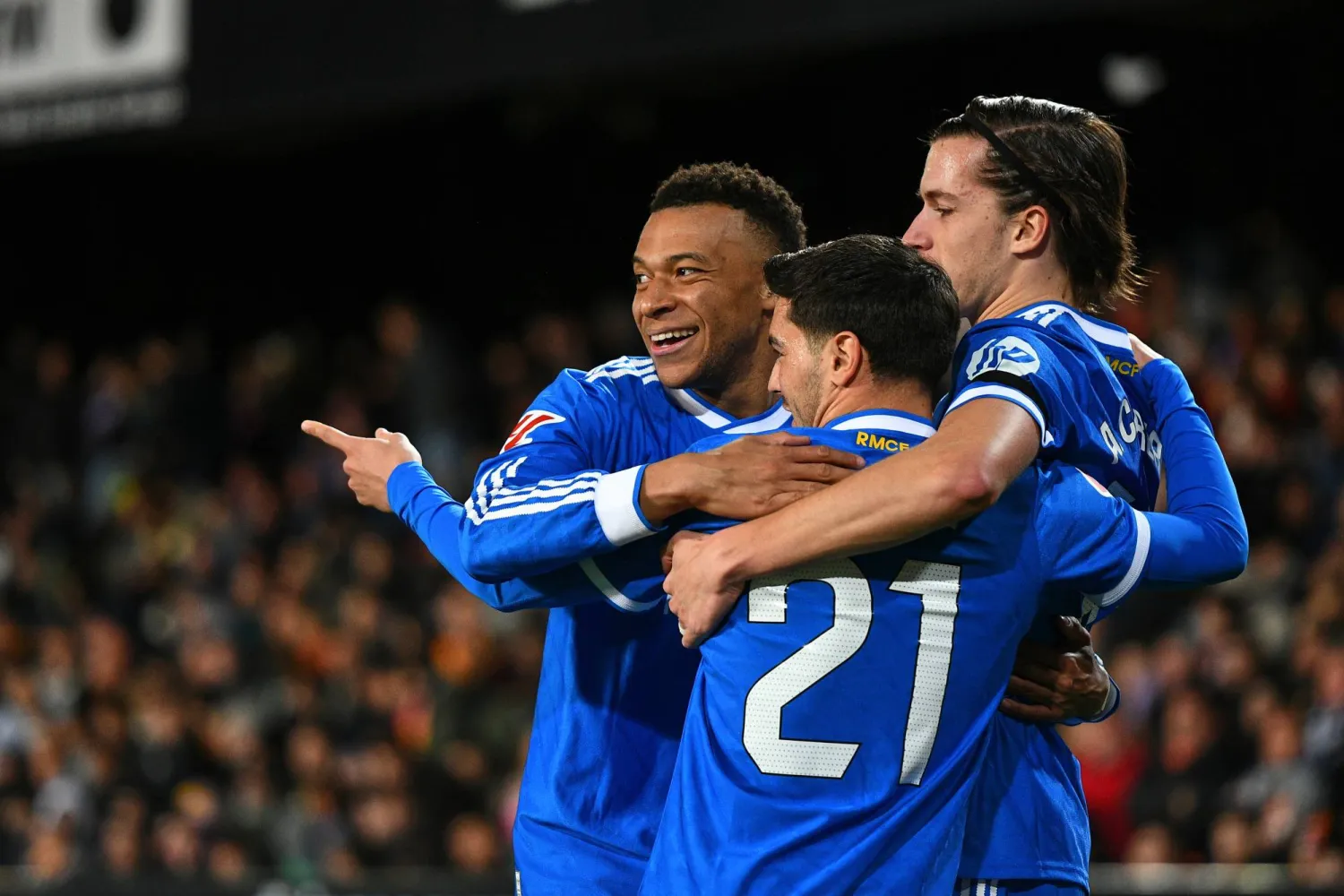 Real Madrid's Kylian Mbappe, left, celebrates with Alvaro Carreras, right, and Brahim Diaz after scoring his side's second goal during the Spanish LaLiga match between Valencia and Real Madrid in Valencia, Spain, Sunday, Feb. 8, 2026. (AP)