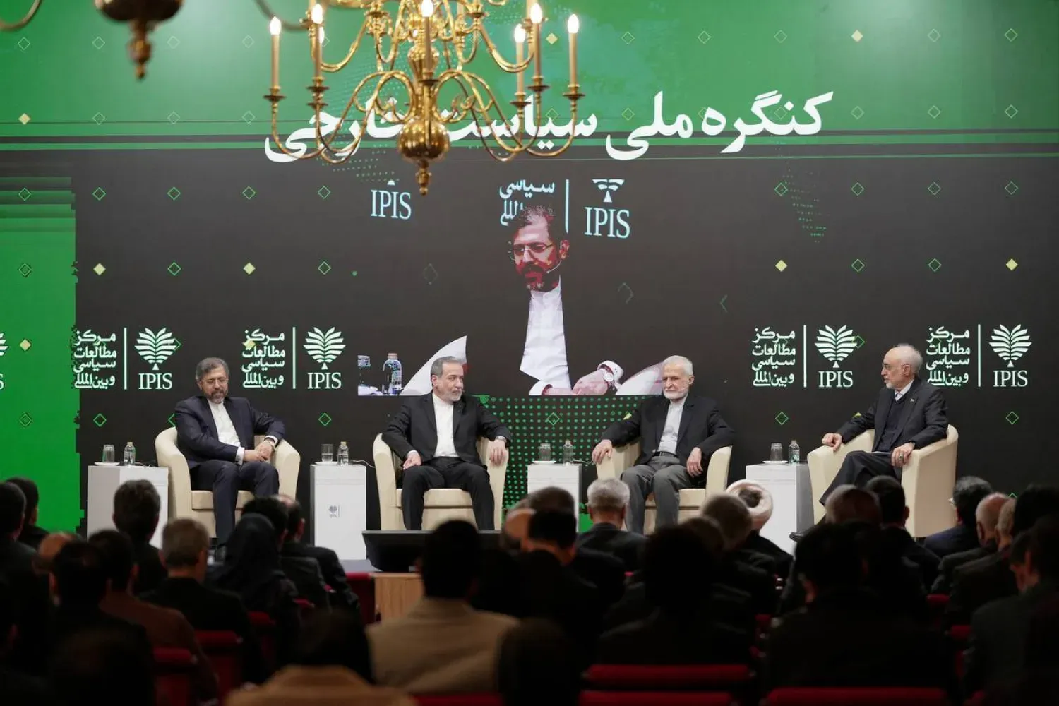 Arakçi, Dış Politika Forumu'na katılıyor ve solunda Yüksek Dış Politika Komitesi Başkanı Kemal Harrazi ve eski Dışişleri Bakanı Ali Ekbar Salihi bulunuyor. Oturumun moderatörlüğünü İran Dışişleri Bakanlığı Diplomatik Araştırma Merkezi Başkanı Said Hatibzade yapıyor.