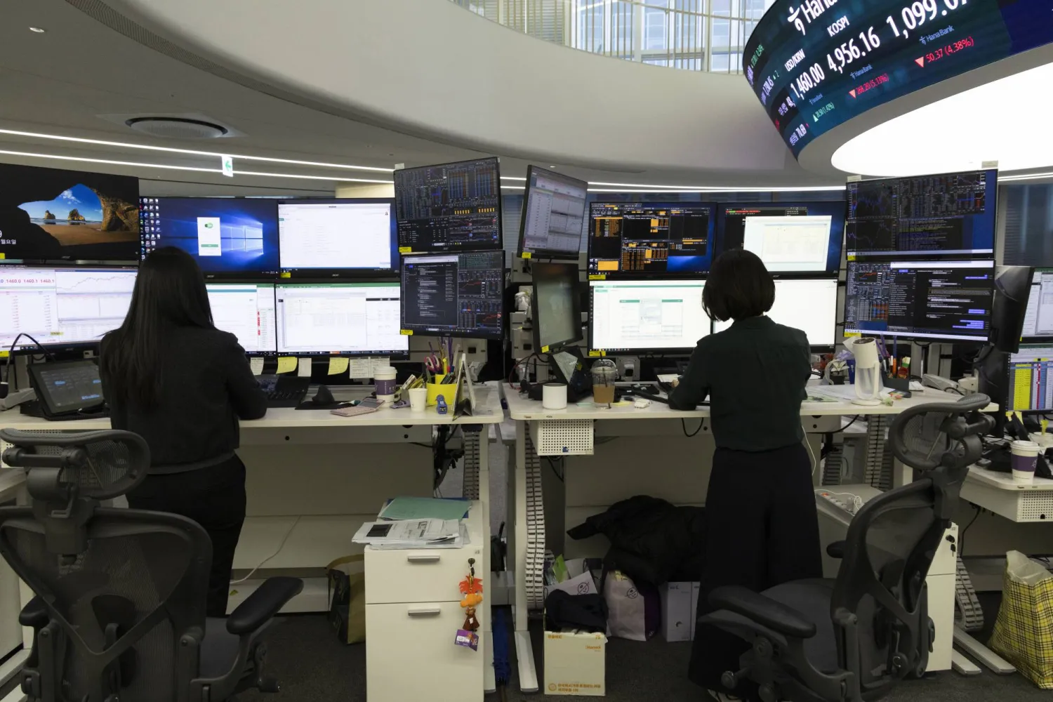 يعمل متداولون كوريون جنوبيون أمام شاشات تعرض مؤشرات الأسهم ببنك هانا في سيول (إ.ب.أ)
