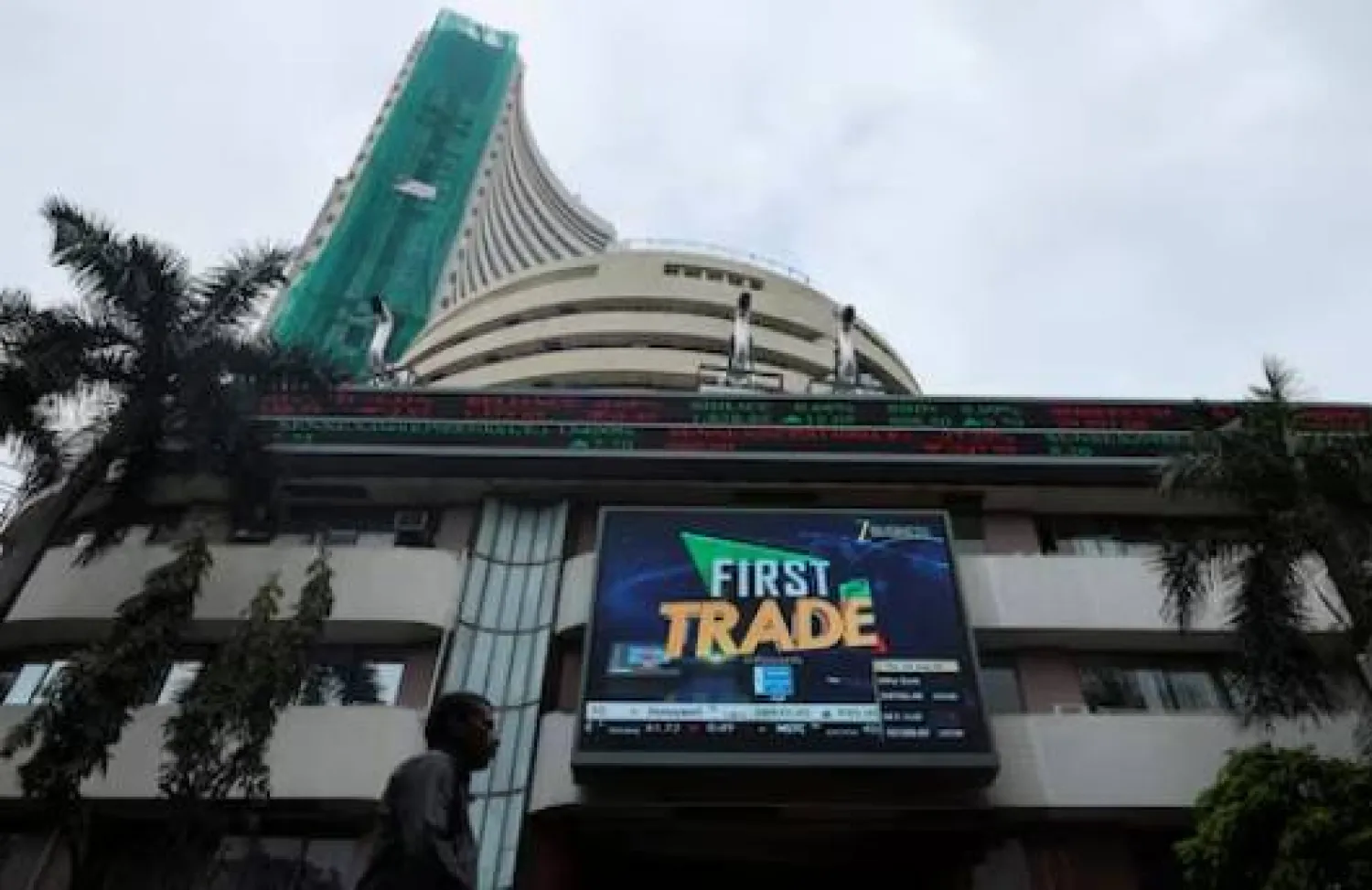 رجل يمشي بالقرب من شاشة خارج بورصة مومباي (رويترز)