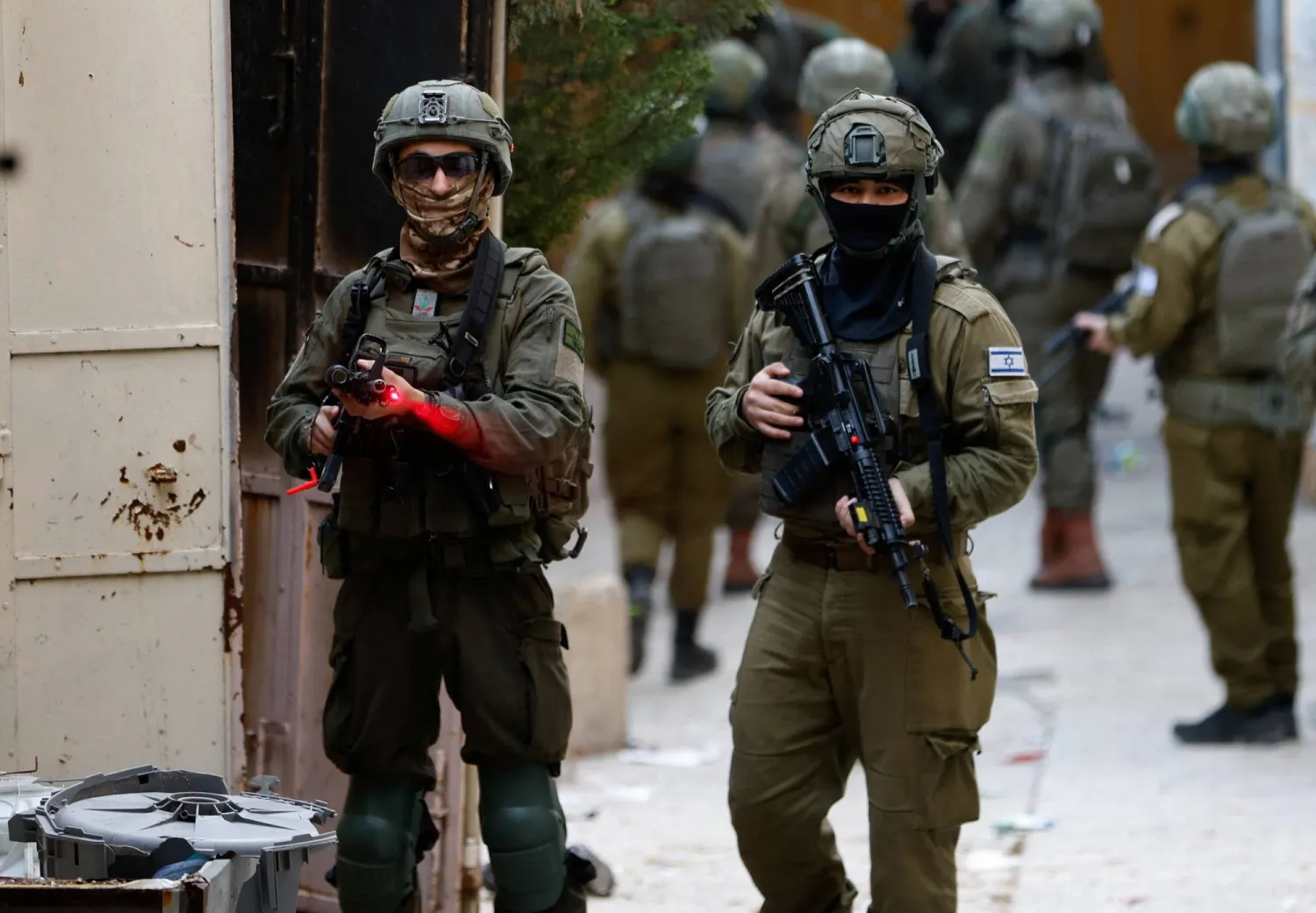  Israeli soldier points his weapon towards the camera, during a weekly settlers' tour in Hebron, in the Israeli-occupied West Bank, February 7, 2026. (Reuters)