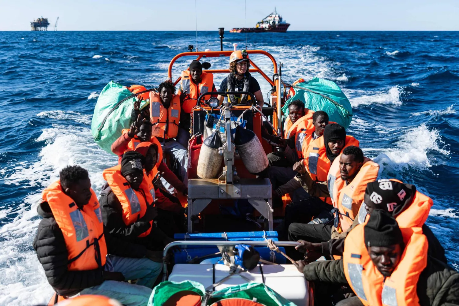 (FILES) Migrants sit on board a RHIB (Rigid inflatable boat) after being evacuated by crew members of the “Ocean Viking” rescue ship from the oil tanker the 'Maridive 703' in the search-and-rescue zone of the international waters between Malta and Tunisia, on December 31, 2025. (Photo by Sameer Al-DOUMY / AFP)