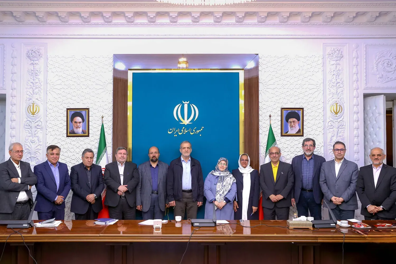 İran Cumhurbaşkanı Mesud Pezeşkiyan, Reform Cephesi Merkez Komitesi üyeleriyle hatıra fotoğrafı çektirirken; yanında Âzer Mansuri yer alıyor, Şekuri Rad görülüyor; arkada İran bayrağı bulunuyor. Kasım 2024 (İran Cumhurbaşkanlığı)