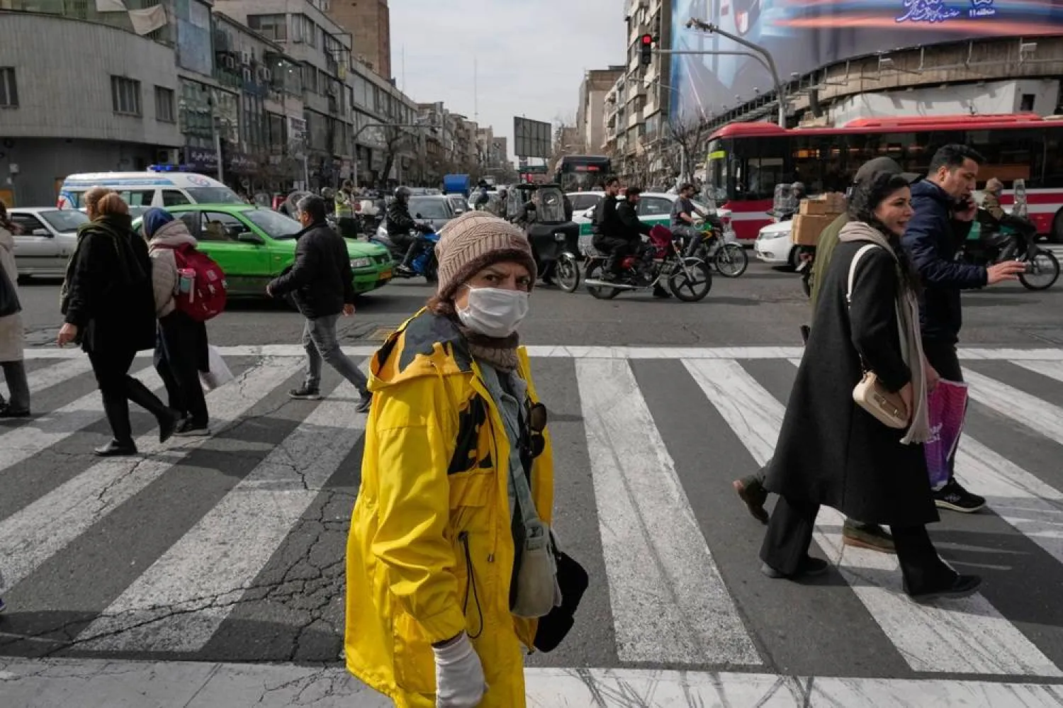People cross an intersection in downtown Tehran, Iran, Monday, Feb. 9, 2026. (AP)