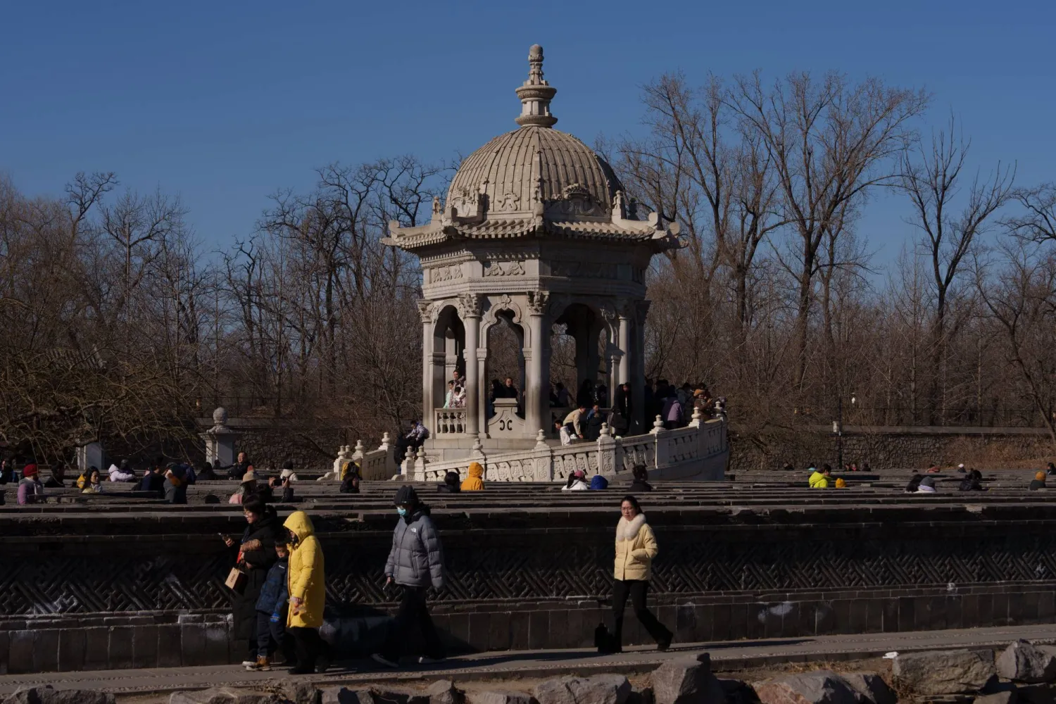 زوار يمرون بجوار جناح بالقرب من أطلال القصر الصيفي القديم المعروف أيضاً باسم يوانمينغ يوان في بكين (أ.ب)