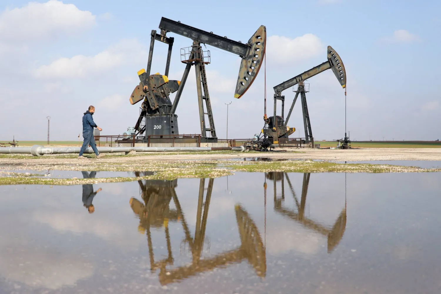 A man walks next to pumpjacks on the day a Syrian government delegation visits the oil-rich city of Rmeilan to inspect oil fields and finalize agreements signed between the Syrian government and the Syrian Democratic Forces (SDF), in Rmeilan, Syria, February 9, 2026. (Reuters)