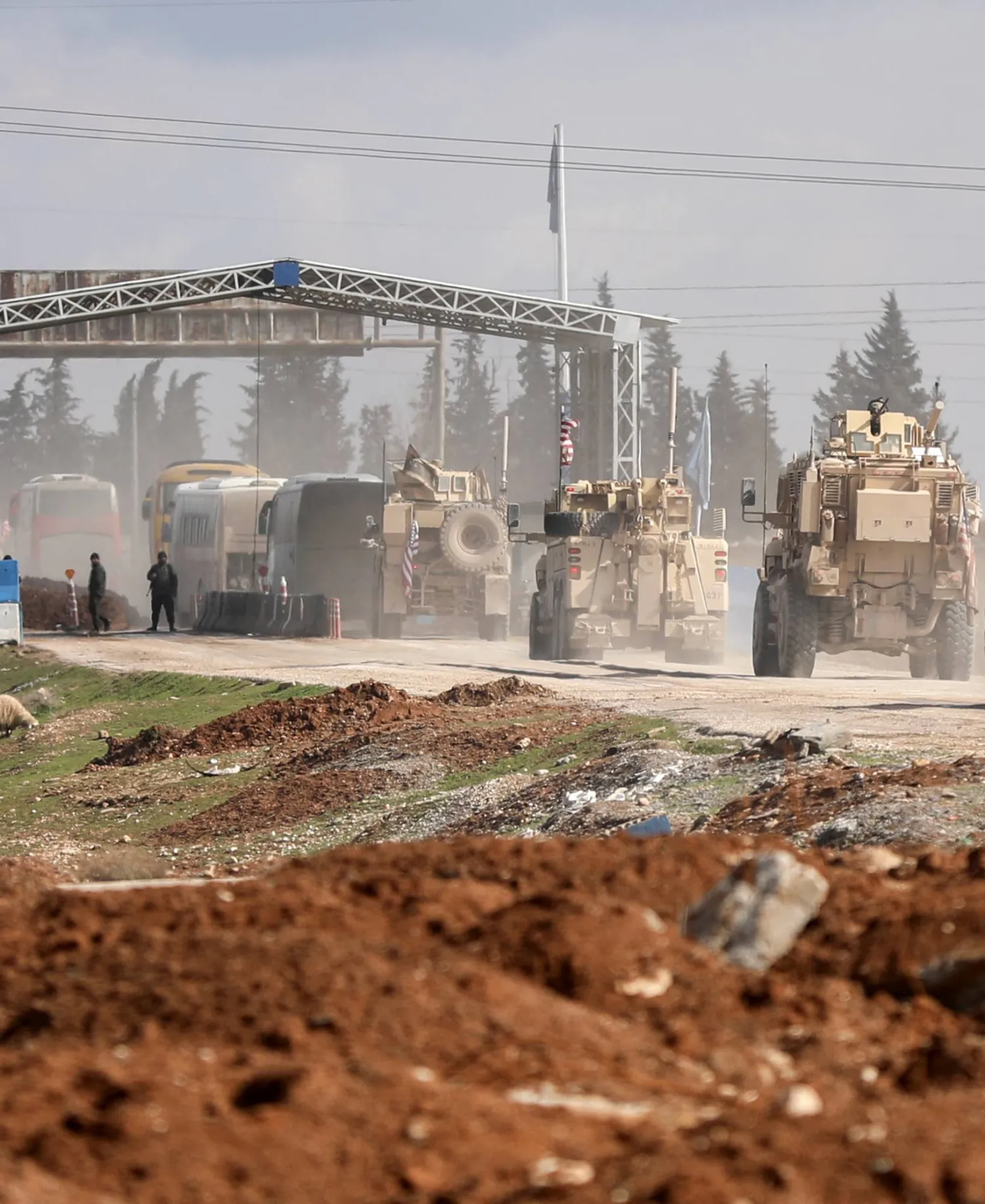 مركبات عسكرية أميركية ترافق حافلات تنقل معتقلي تنظيم «داعش» من سوريا إلى العراق في مدينة القامشلي السورية - 8 فبراير 2026 (رويترز)