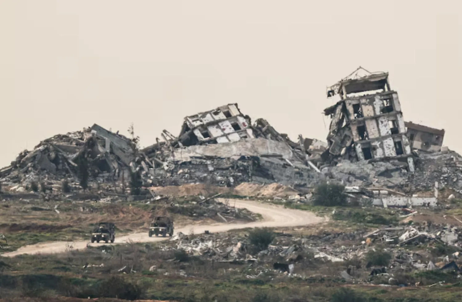 Israeli military vehicles drive past destruction in Gaza, as seen from the Israeli side of the Israel-Gaza border in southern Israel, January 21, 2026. REUTERS/Amir Cohen/File Photo 