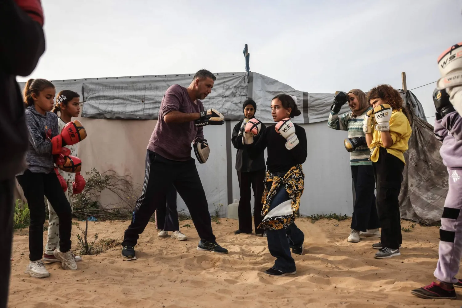 Palestinian girls and young women attend a boxing training session between displacement tents in Khan Younis, in the southern Gaza Strip, on February 9, 2026. (AFP)