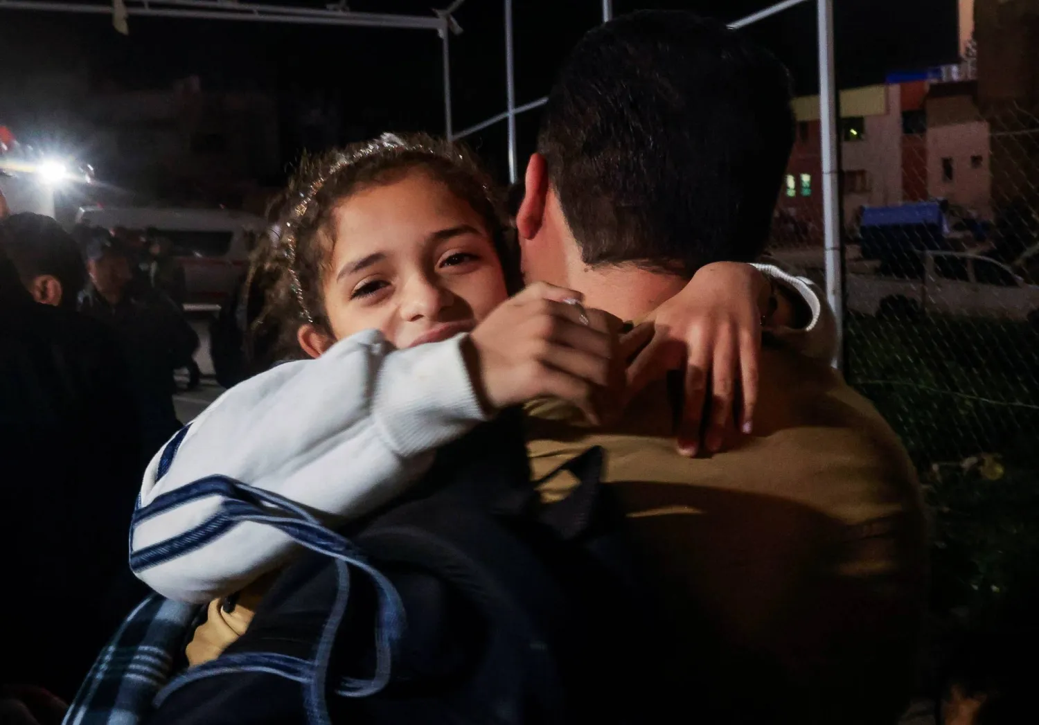 فلسطيني يحمل طفلة بينما يصل الفلسطينيون القادمون من معبر رفح الحدودي إلى مستشفى ناصر في خان يونس جنوب قطاع غزة يوم 9 فبراير الحالي (رويترز)