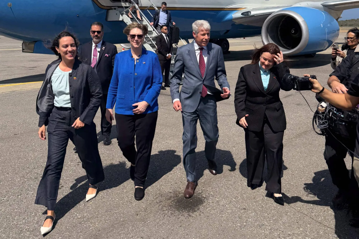 Handout picture released by the US Embassy in Venezuela showing US Secretary of Energy Chris Wright (2-R) walking next to the new head of the United States diplomatic mission for Venezuela, Laura Dogu (2-L), upon his arrival at Maiquetia International Airport in Maiquetia, La Guaira state, Venezuela, on February 11, 2026. (Handout / US Embassy in Venezuela / AFP) 