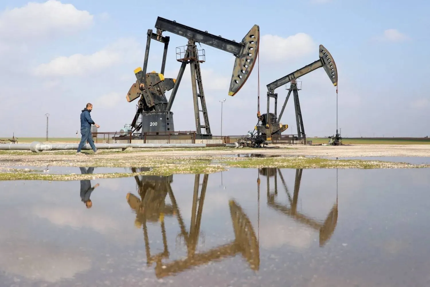 A man walks past oil pumps in the oil-rich city of Rmelan in Syria (Reuters)