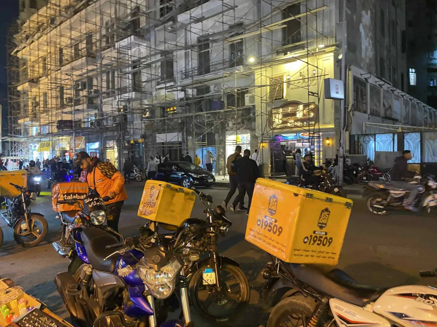 الشاب كريم ياسر خلال انتظاره لطلب من مطعم لتوصيله (الشرق الأوسط)