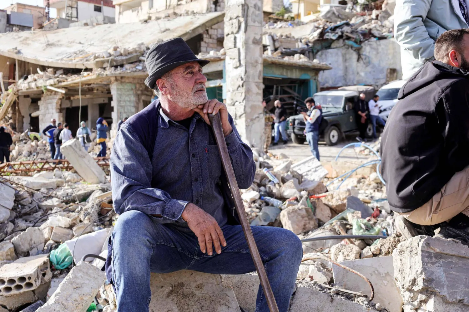 لبناني من سكان بلدة كفركلا الحدودية مع إسرائيل في جنوب لبنان ينتظر وصول رئيس الحكومة نواف سلام للبلدة المدمرة جراء الحرب خلال زيارة له الأحد إلى المنطقة (أ.ف.ب)