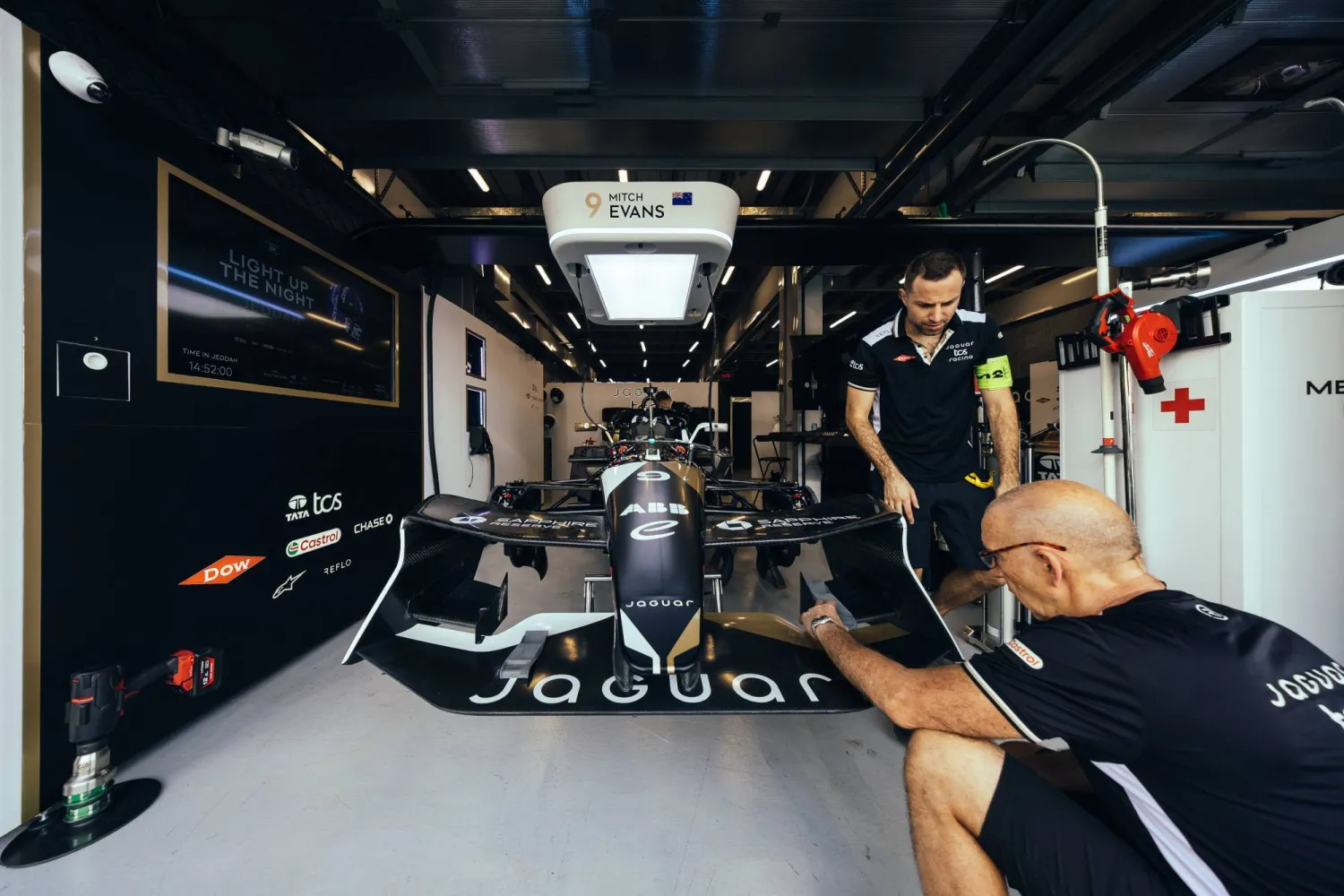 سائق ومساعده يجهزان سيارتهما في انتظار السباق الجمعة (الاتحاد السعودي للسيارات)