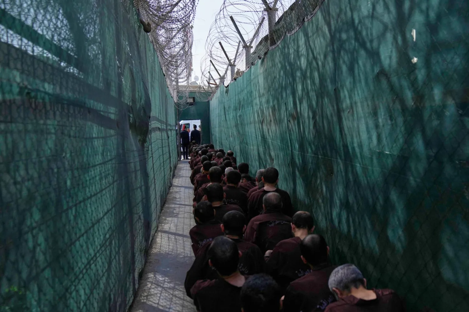 Iraqi security forces lead suspected ISIS militants for questioning, after they were transferred from Syria to Iraq, at Al-Karkh Central Prison in Baghdad, Iraq, Thursday, Feb. 12, 2026. (AP Photo/Hadi Mizban)
