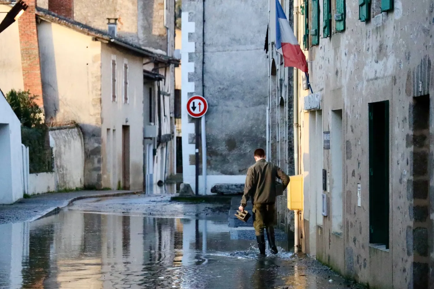 A man walks along a flooded street of Saint-Germain de Confolens as severe flooding hits western France amid storm Nils, Thursday, Feb. 12, 2026. (AP)