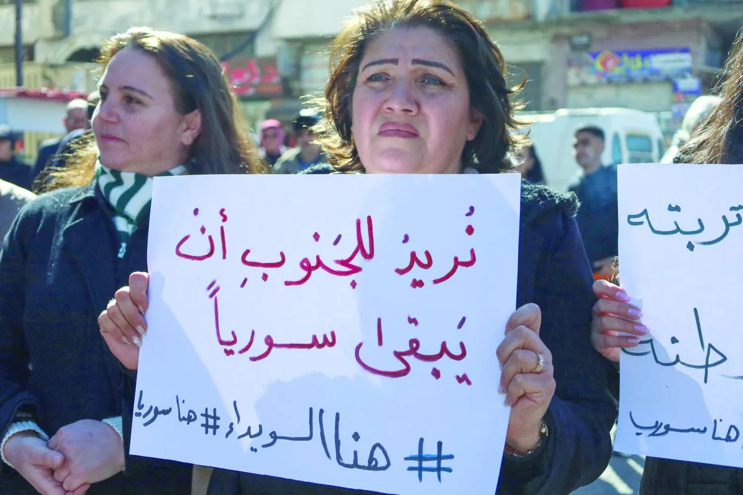 سوريون يرفعون لافتات في «ساحة الكرامة» المركزية بمدينة السويداء في جنوب سوريا 25 فبراير 2025 (أ.ف.ب)