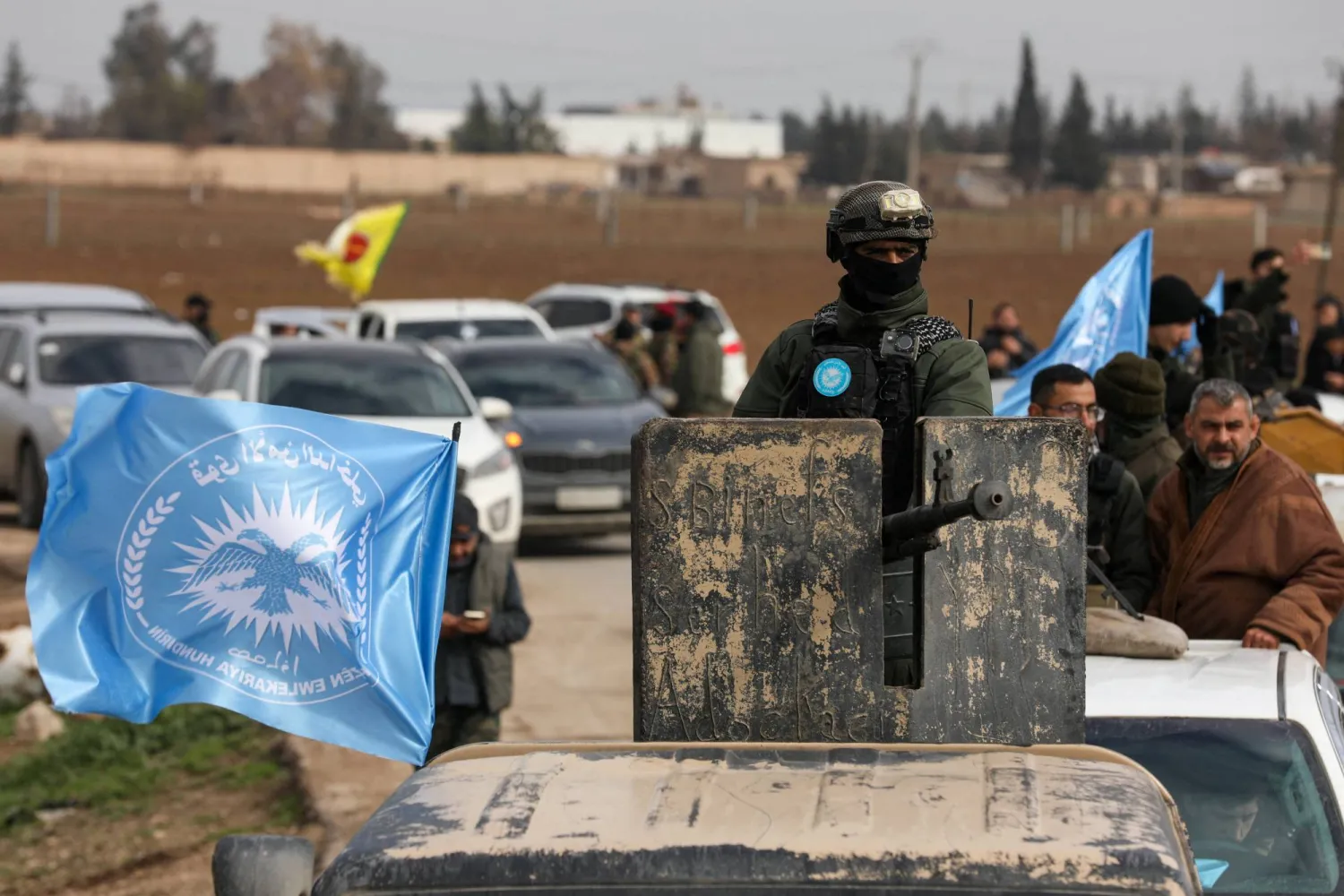 يقوم أحد أفراد قوات الأمن الداخلي الكردية بتشغيل مدفع رشاش مثبت على مركبة في حين يتجه هو وآخرون نحو خطوط المواجهة على مشارف مدينة تل حمس عقب الاتفاق بين «قسد» وحكومة دمشق (رويترز)