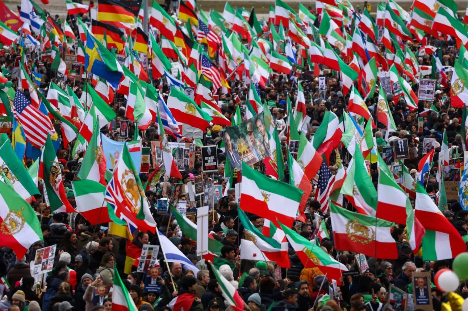 Protesters wave flags - with a lion and a sun against horizontal green, white and red stripes, the emblem of the monarchy overthrown in 1979- during a demonstration in Munich (Reuters).