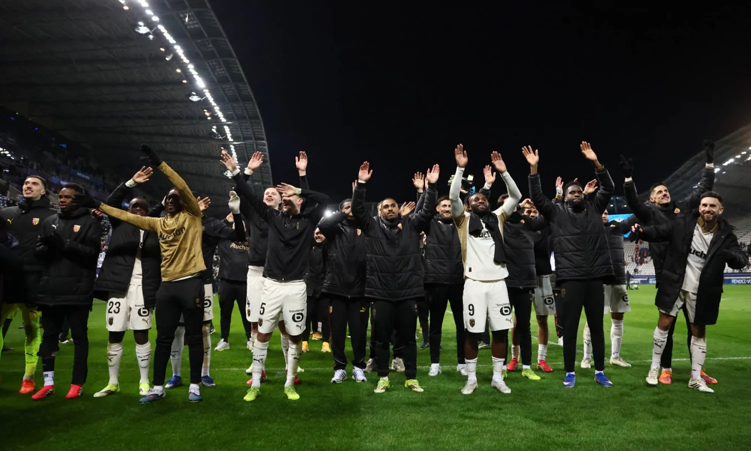 لاعبو لانس يحتفلون مع جماهيرهم بعد الفوز (رويترز)