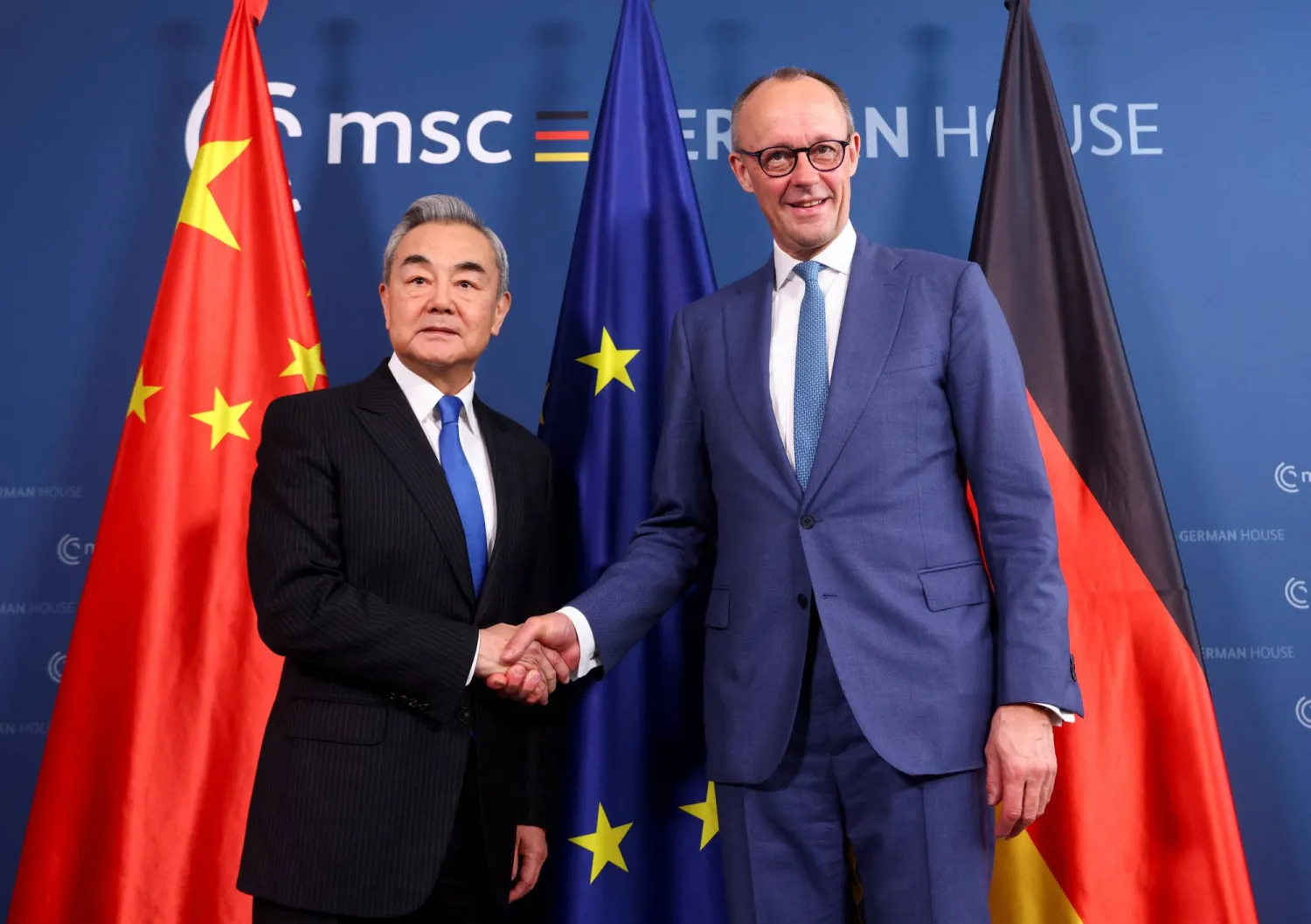  14 February 2026, Bavaria, Munich: German Chancellor Friedrich Merz (R) shakes hands with Chinese Foreign Minister Wang Yi for a joint meeting on the sidelines of the Munich Security Conference. (Thilo Schmuelgen/Reuters/Pool/dpa)