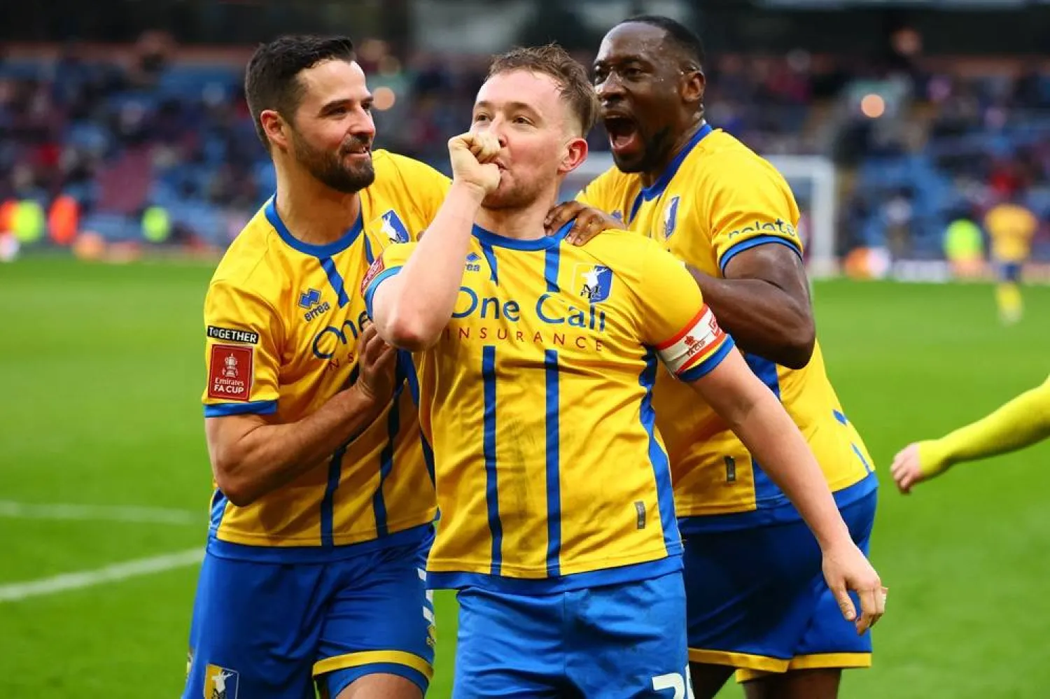 Mansfield Town's English midfielder #25 Louis Reed (C) celebrates with teammates after scoring their second goal during the English FA Cup fourth round football match between Burnley and Mansfield Town at Turf Moor in Burnley, northwest England on February 14, 2026. (AFP)