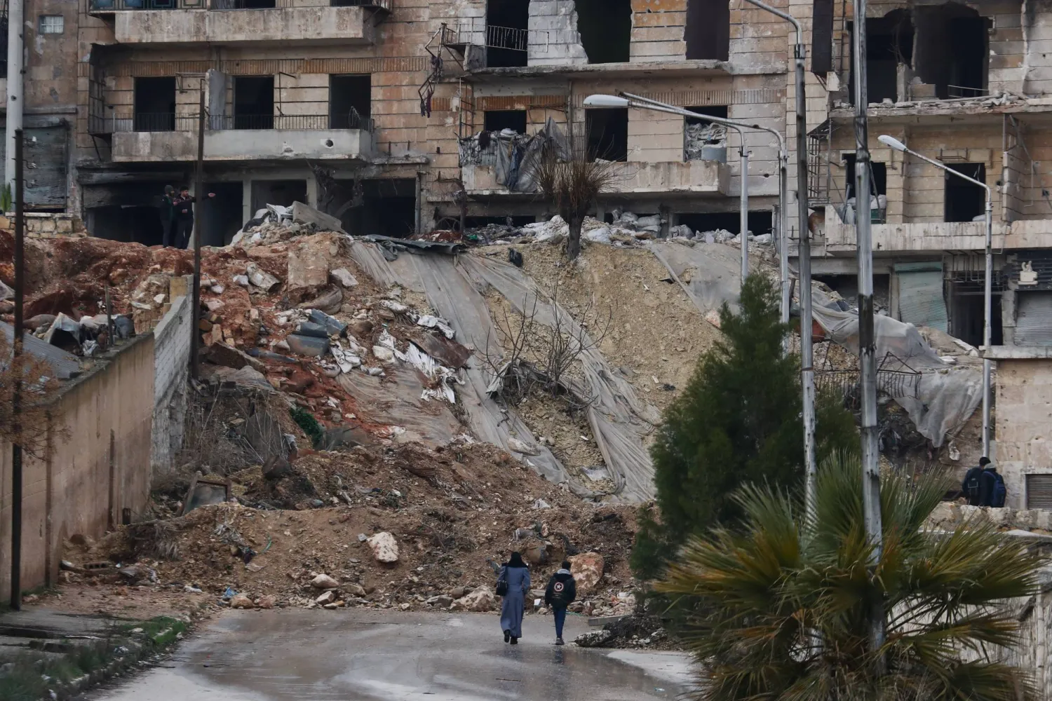 سكان من حي الشيخ مقصود ذي الأغلبية الكردية في حلب شمال سوريا يعودون للحي رغم الدمار السبت 14 فبراير (أ.ب)