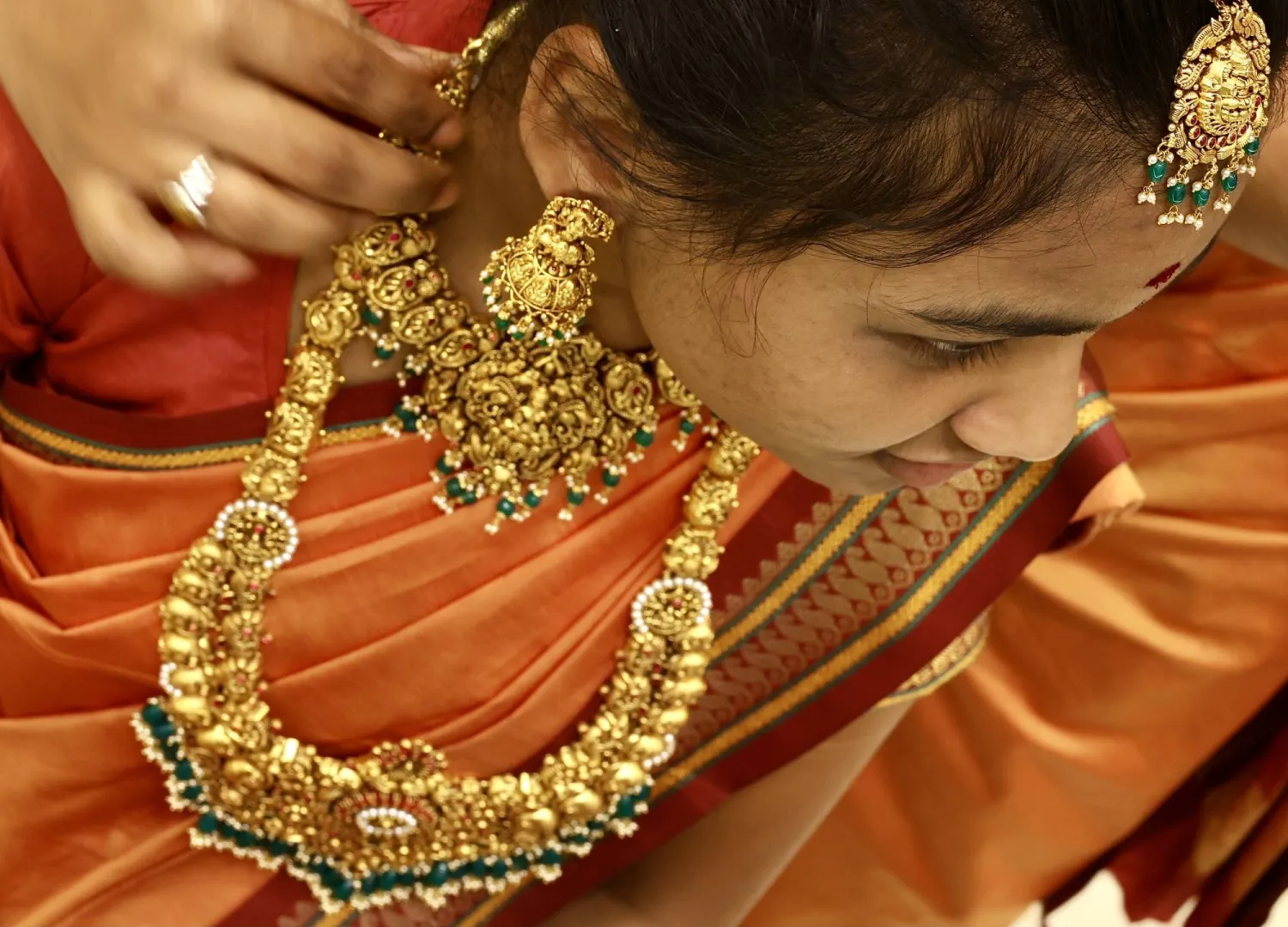 امرأة هندية تجرب حلياً ذهبية في متجر مجوهرات في بنغالور (إ.ب.أ)